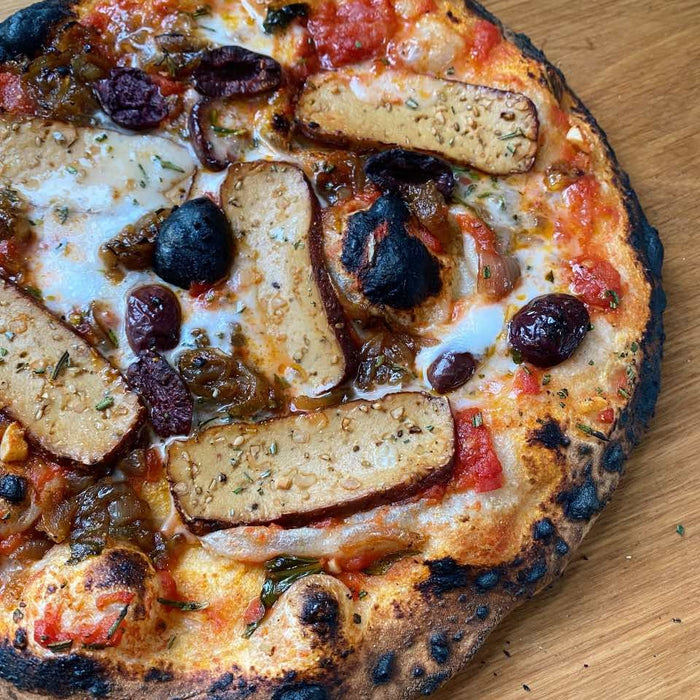 Pizza mit geräuchertem Tofu und karamellisierten Zwiebeln mit veganem Feta, Oliven und Rosmarin