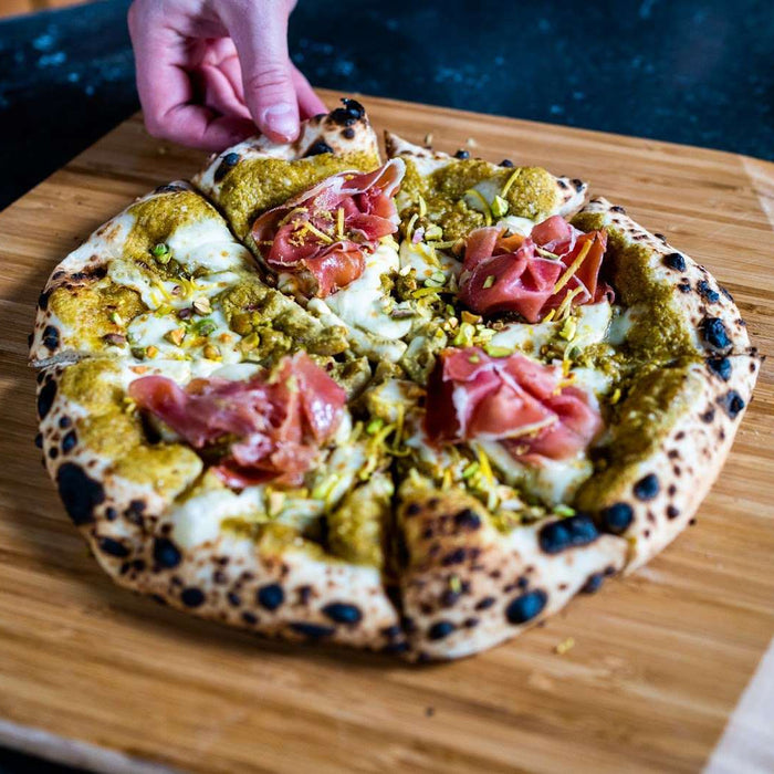 Pizza mit Pistaziencreme, Mozzarella, Pecorino und Rohschinken