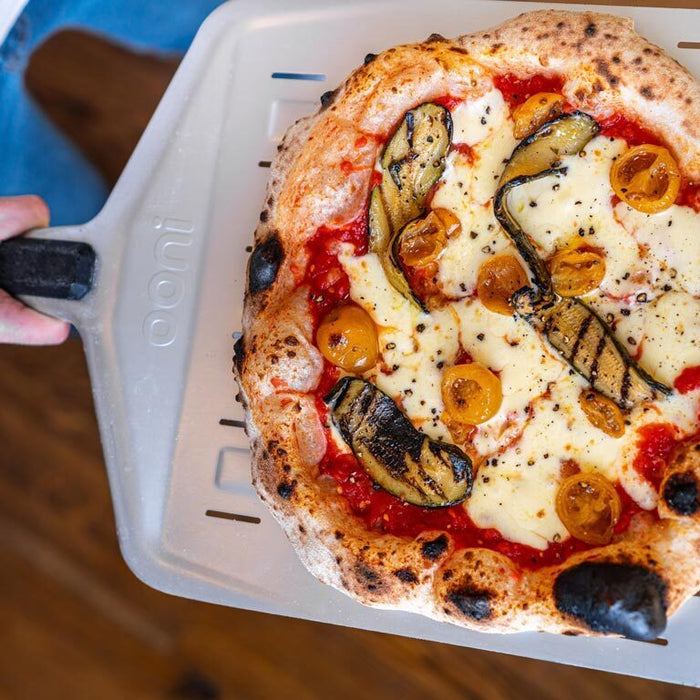 Pizza mit Flammen gegarter Zucchini und Kirsch Tomate